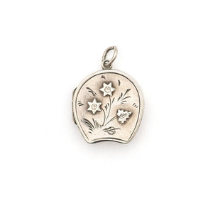 This horseshoe-shaped oval English sterling silver locket features two star flowers and one leaf in raised relief with delicately etched stems and leaves in the background. It has been hallmarked for Birmingham, 1901, opens to hold two photos and pairs perfectly with one of our vintage sterling silver chains. Front locket view