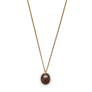 This unique lock charm is carved out of walnut wood and has intricate carving details along the surface and a "key hole." Paired with one of our vintage gold fill chains, this rare charm can be worn both as a alone as a pendant or in a cluster of charms.  Front charm view, shown on chain