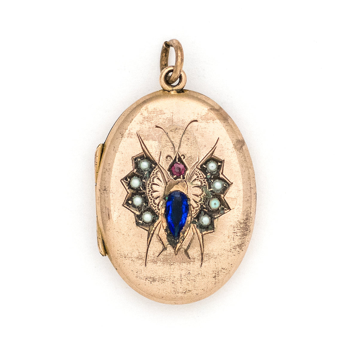 This unique oval Victorian locket features blue and red stones and seed pearls set within a finely etched bug design. It opens to hold one photo, and pairs perfectly with one of our antique gold fill chains.  Front locket view
