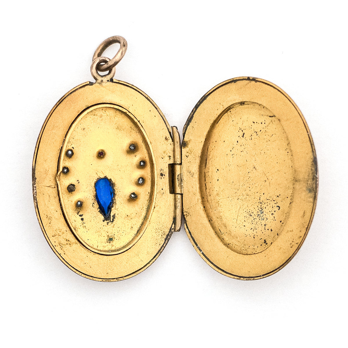 This unique oval Victorian locket features blue and red stones and seed pearls set within a finely etched bug design. It opens to hold one photo, and pairs perfectly with one of our antique gold fill chains.  Open locket view