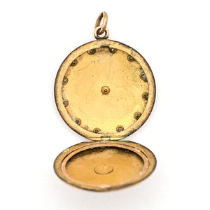 This round, matte locket features a starburst at the its center with a gorgeous border in Art Deco style and white paste stones throughout the design. It opens to hold one photo, includes one original frame and pairs perfectly with one of our antique gold fill chains.  Open locket view