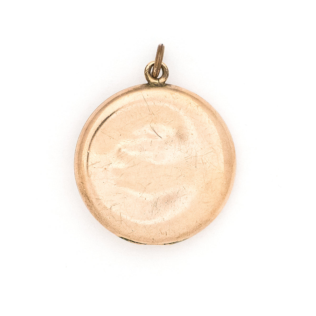 This romantic round Edwardian locket features a playful swirling pattern framing a sizable white paste stone at its center, and a polished verso.  It opens to hold two photos, includes both original frames and pairs perfectly with one of our antique gold fill chains.  Back locket view