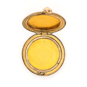 This round locket features a beautifully stylized cursive "G", complete with accenting flourishes. It opens to hold two photos, includes both original frames and pairs perfectly with one of our antique gold fill chains. Open locket view
