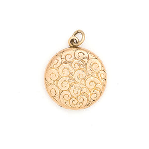 This lively round locket features a repeating curlicue and swirl pattern which covers the entire locket face. It opens to hold two photos, includes both original frames and pairs perfectly with one of our antique gold fill chains. Front locket view