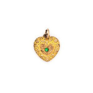 This petite heart shaped Victorian charm features a raised flourish design around its border and a green glass stone at its center. This classic charms pairs perfectly with one of our antique chains. Front charm view