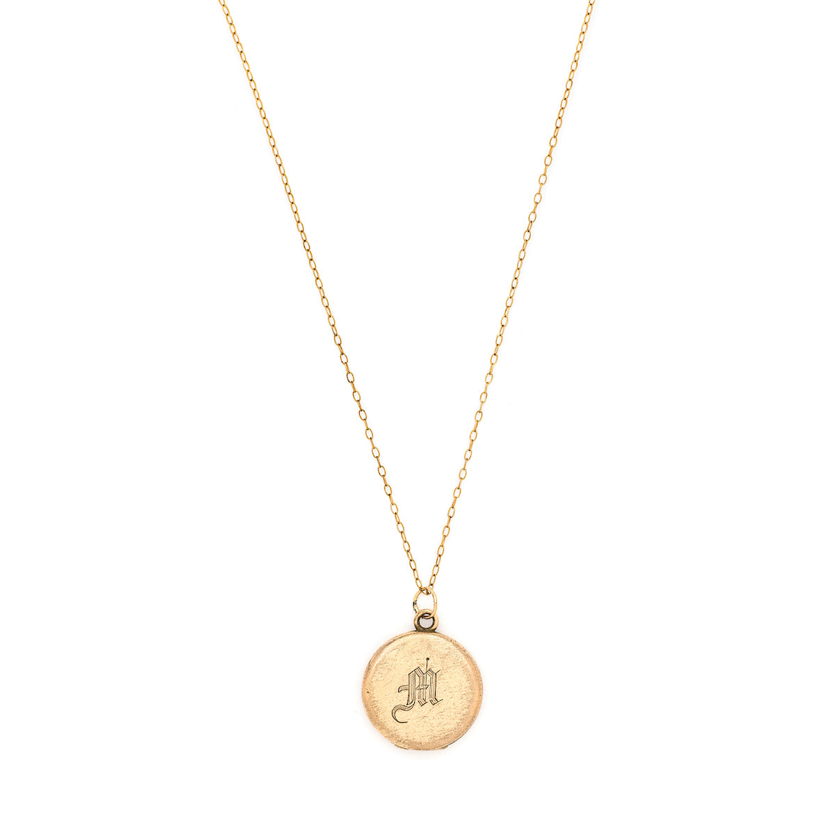 This petite round locket features a simple "M" in Old English script. It opens to hold two photos, includes both original frames and pairs perfectly with one of our antique gold fill chains. Front locket view, shown on chain