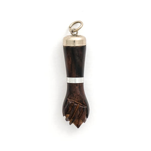 This unique figa hand charm is made of walnut wood and features sterling silver accents including the bail and a bracelet on the wrist. The figa symbol dates back to ancient times and in modern day is seen as a sign of female strength and empowerment. Paired with one of our antique sterling silver chains, this charm can be worn both as a pendant or in a cluster of charms.  Front charm view