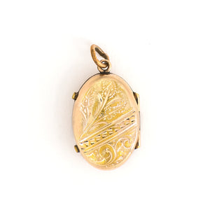 This unique oval locket features a delicate design with sky, navy blue and black enamel set on a finely textured background. The background features floral accents and a cross bar in the same instricate style. It opens to hold two photos, includes both original frames and glass and pairs perfectly with one of our antique gold fill chains.  Back locket view