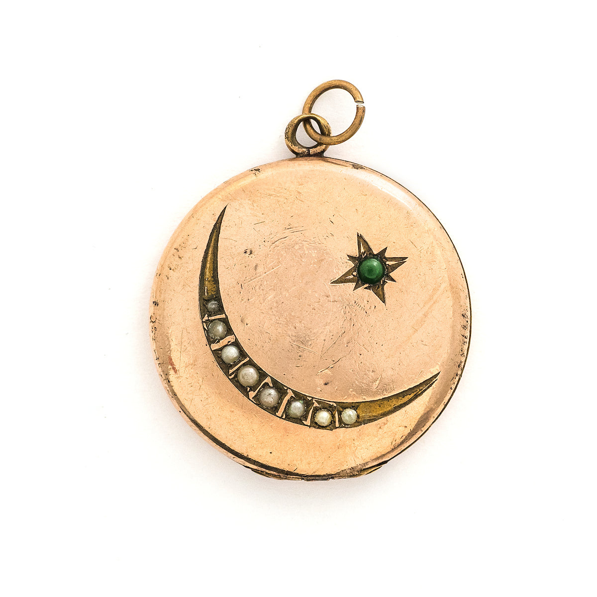 This Victorian round locket features a classic crescent moon and starburst, with a pearl encrusted crescent and jade as the center of the starburst. The letters "JO" are inscribed on the back. It opens to hold two photos and pairs perfectly with one of our antique gold fill chains. Front locket view