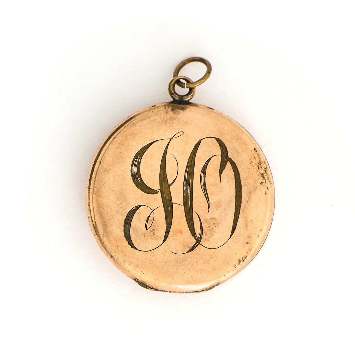 This Victorian round locket features a classic crescent moon and starburst, with a pearl encrusted crescent and jade as the center of the starburst. The letters "JO" are inscribed on the back. It opens to hold two photos and pairs perfectly with one of our antique gold fill chains. Back locket view
