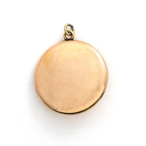 This detailed round locket features an intricate pattern reminiscent of rolling waves with two blue and one multicolored glass stones at it's center. It opens to hold two photos and pairs perfectly with one of our antique gold fill chains.  Back locket view