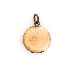 This petite round locket features red and white stones in an alternating pattern and a larger white stone at the center of a star. It opens to hold one photo and pairs perfectly with one of our antique gold fill chains.  Back locket view
