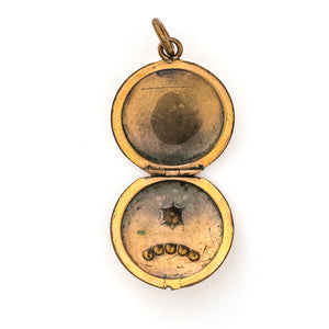 This petite round locket features red and white stones in an alternating pattern and a larger white stone at the center of a star. It opens to hold one photo and pairs perfectly with one of our antique gold fill chains.  Open locket view