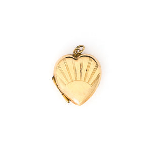 This lustrous 9K gold heart locket features a rising sun design across the entire front. It opened to hold two photos, has both original frames and paired with one of our vintage gold chains, this locket is the perfect symbol of love and new beginnings. Front locket view