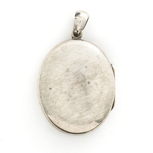 This large oval sterling silver locket features a finely etched swallow and bamboo scene, complete with rolling hills in the back drop. It opens to hold two photos and pairs perfectly with one of our antique sterling silver chains. Back locket view
