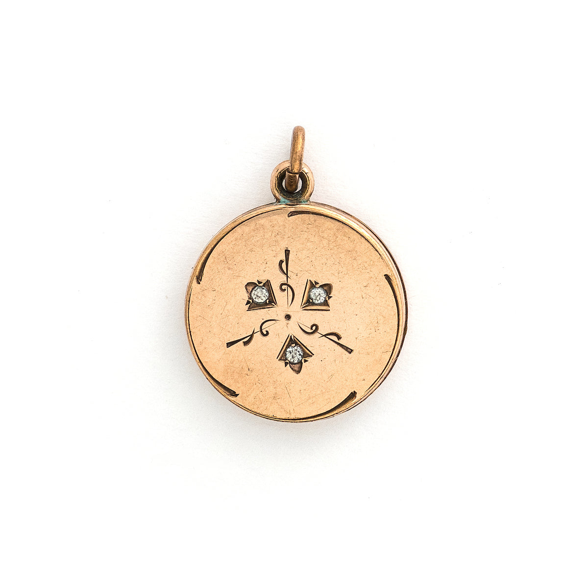 This simple round slide locket features 3 white glass stones and a minimalist thirds design. It slides opens to hold two photos and pairs perfectly with one of our antique gold fill chains.  Front locket view