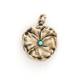 This incredible round locket features a sculpted pansy with a turquoise stone at its center. It is sterling silver with a gold wash and the textured petals catch the light at every turn. It opens to hold two photos and pairs perfectly with one of our antique sterling silver or gold fill chains. Front locket view