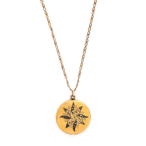 This matte round locket features a playful pinwheel design with white and grey glass stones scattered throughout. The initials CAI are inscribed on the back, it opens to hold two photos, includes both original frames and pairs perfectly with one of our antique gold fill chains. Front locket view, shown on chain