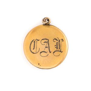 This matte round locket features a playful pinwheel design with white and grey glass stones scattered throughout. The initials CAI are inscribed on the back, it opens to hold two photos, includes both original frames and pairs perfectly with one of our antique gold fill chains. Back locket view