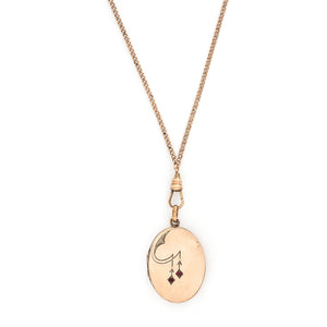This oval locket features a simple Art Deco design with two red floral vines hanging down the center. It opens to hold two photos, includes both original frames and pairs perfectly with one of our antique gold fill chains. Front locket view with chain