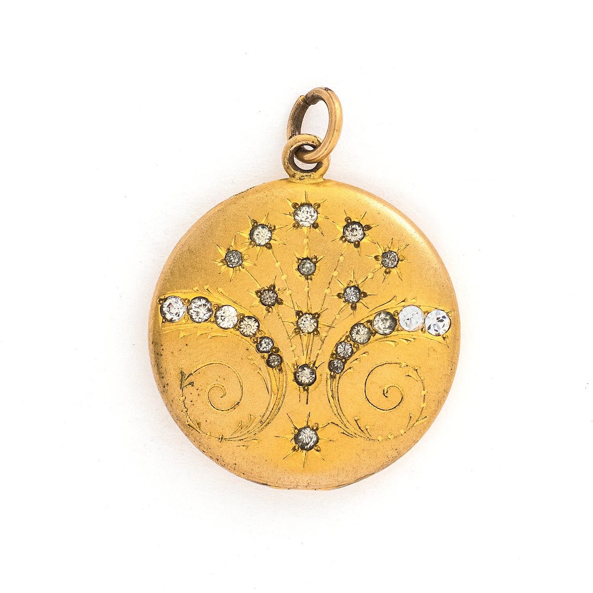 This matte round locket features 23 white glass stones scattered throughout a whimsical pattern of starbursts and ornamental swirls. It opens to hold one photo, includes the original frame and pairs perfectly with one of our antique gold fill chains.   Front locket view