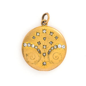 This matte round locket features 23 white glass stones scattered throughout a whimsical pattern of starbursts and ornamental swirls. It opens to hold one photo, includes the original frame and pairs perfectly with one of our antique gold fill chains.   Front locket view