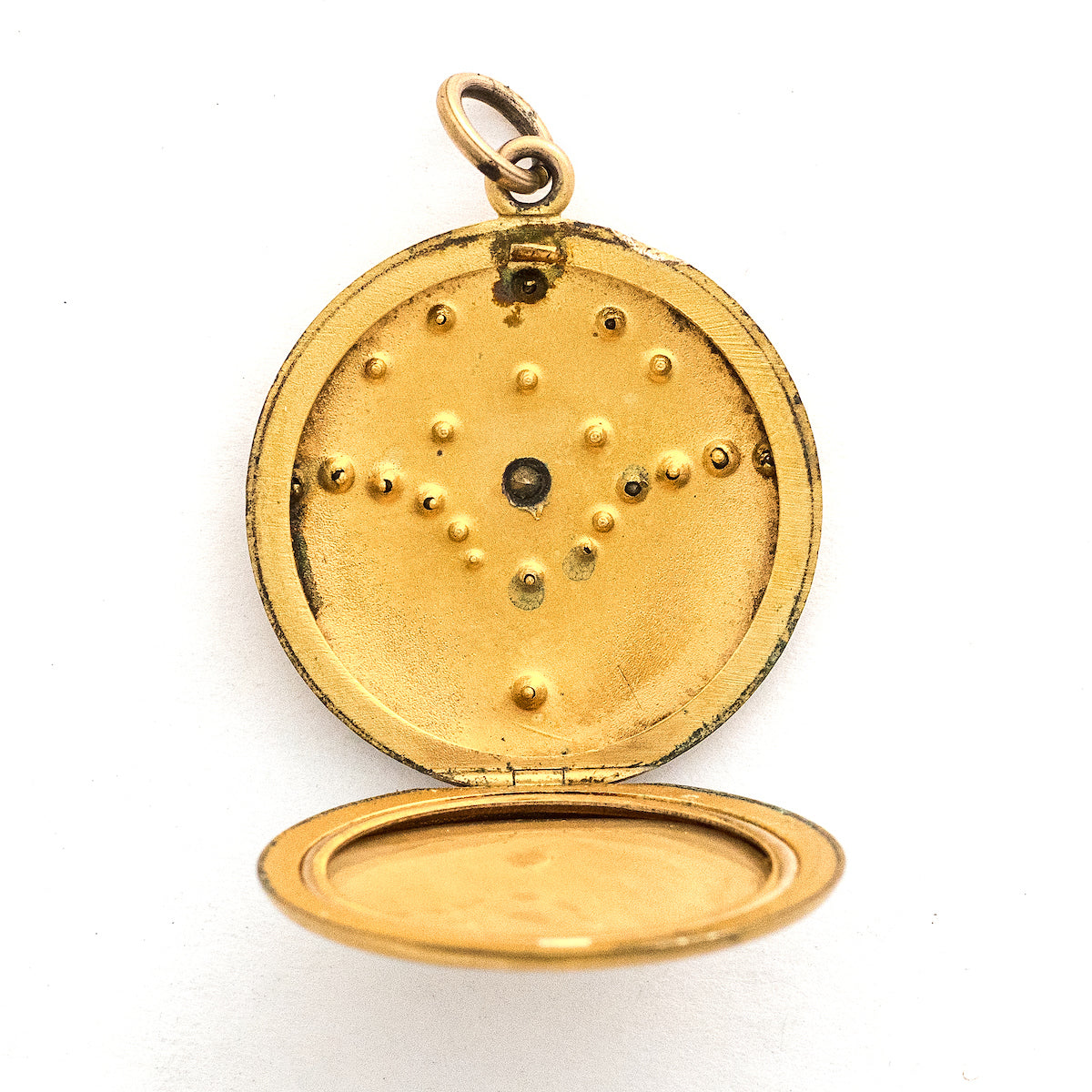 This matte round locket features 23 white glass stones scattered throughout a whimsical pattern of starbursts and ornamental swirls. It opens to hold one photo, includes the original frame and pairs perfectly with one of our antique gold fill chains.  Open locket view