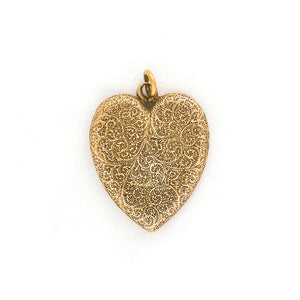 This heart shaped 14K gold locket features an earthy design reminiscent of tree roots with floral accents across the entire front and back of the locket. It opens to hold two photos, includes both original frames and pairs perfectly with one of our antique gold chains. Front locket view