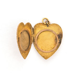 This heart shaped 14K gold locket features an earthy design reminiscent of tree roots with floral accents across the entire front and back of the locket. It opens to hold two photos, includes both original frames and pairs perfectly with one of our antique gold chains. Open locket view